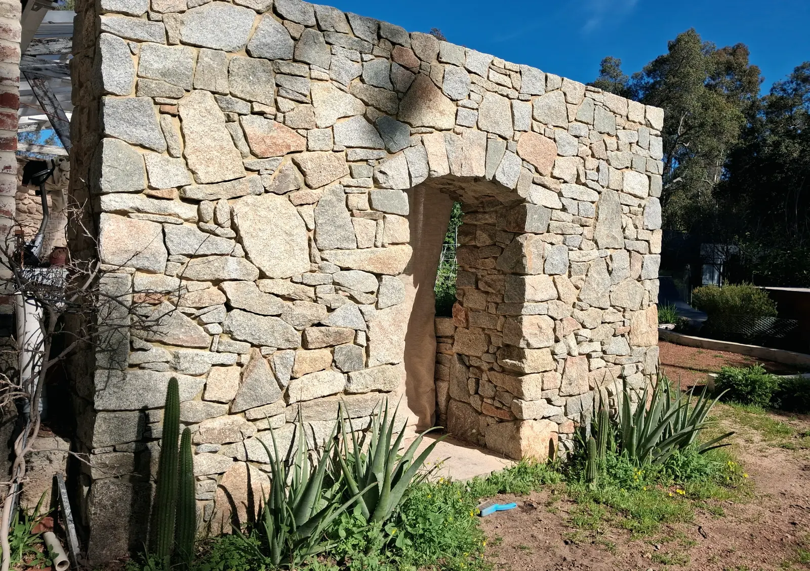 A standing granite wall with a tall hand-cut doorway